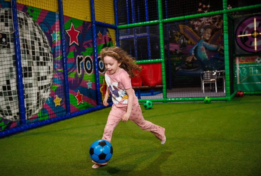 Child playing football inside Wonder World Glasgow